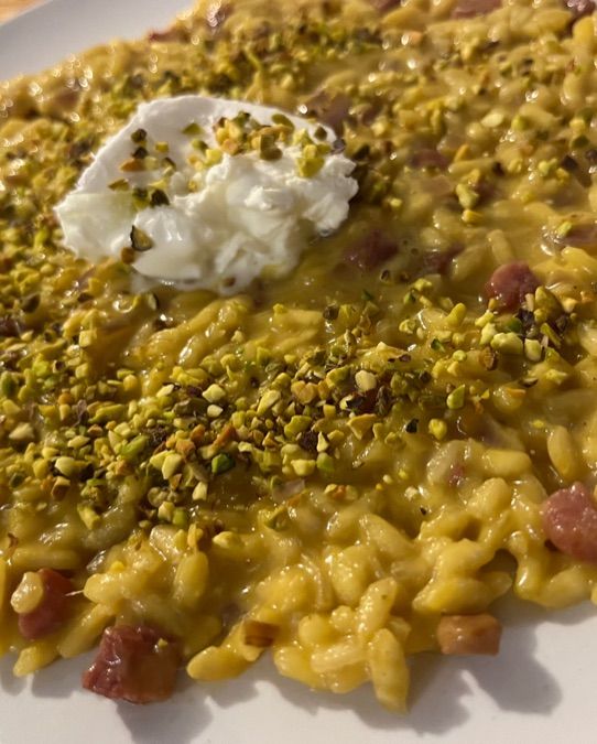 Risotto allo zafferano, mantecato con burrata di bufala, pancetta e pistacchi