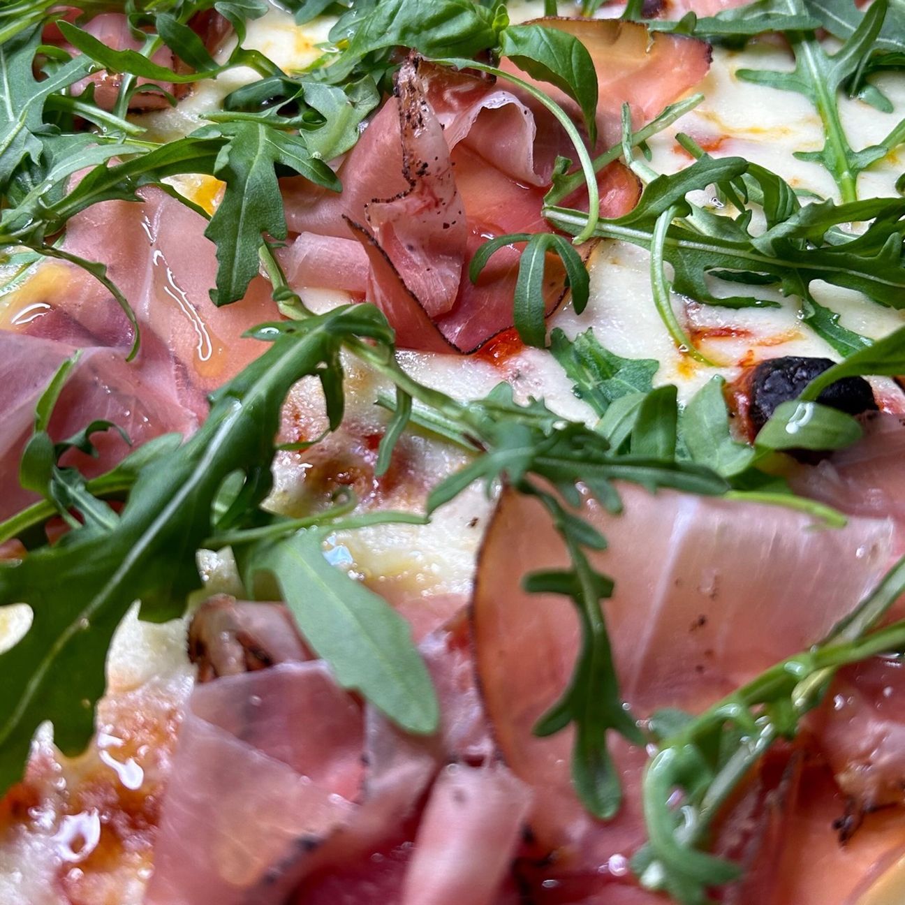 Pizza con mozzarella, rucola e speck