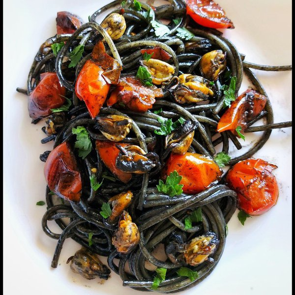 Penne al nero di seppia con calamari e pomodorini