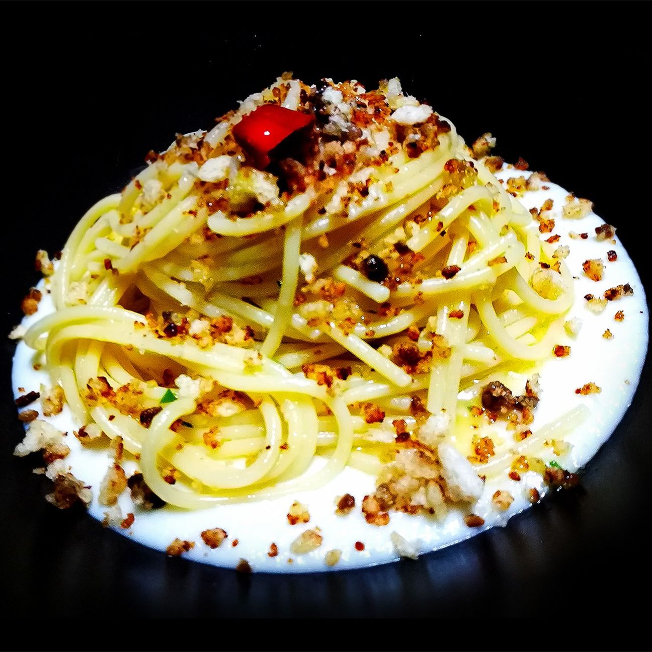 Spaghetto aglio olio e peperoncino su crema di cavolfiore e crumble all'acciuga