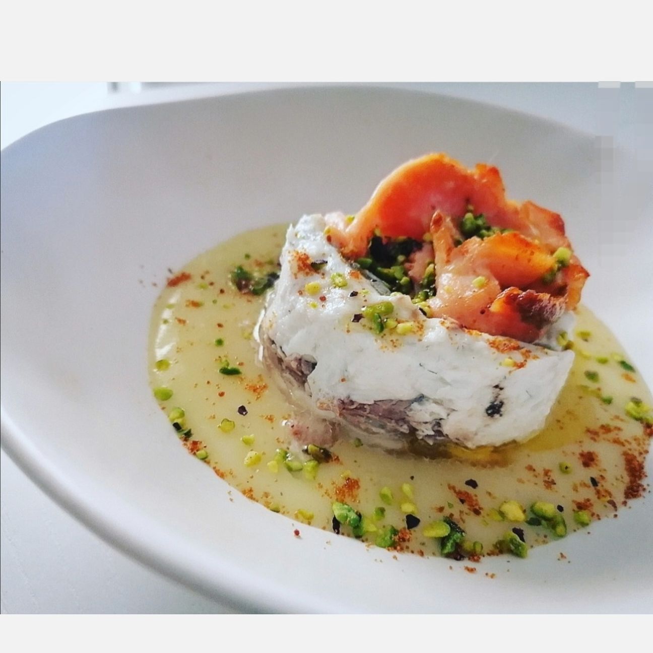 Turbante di orata con rosa di salmone, su crema di patate allo zafferano e granella di pistacchio di Stigliano.
