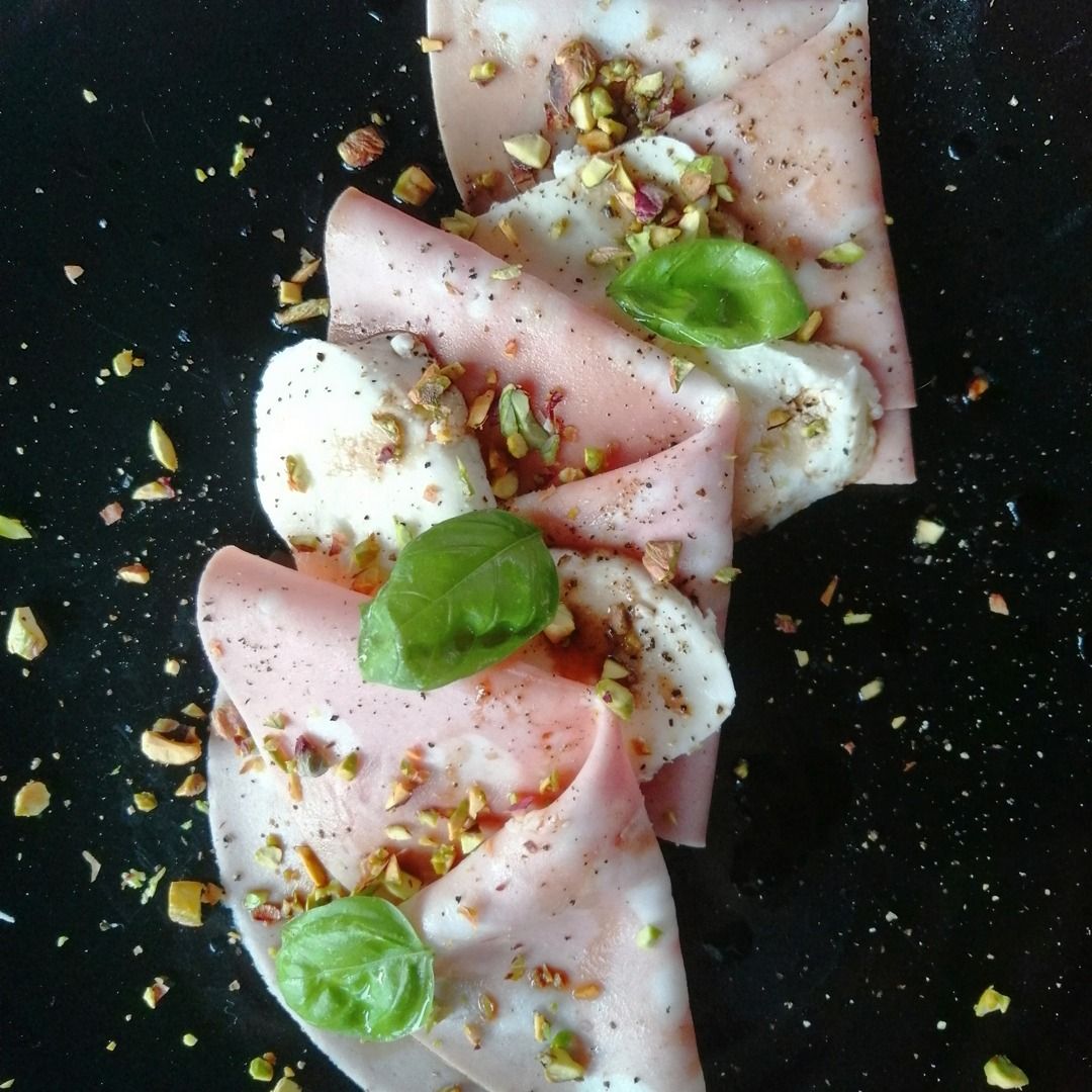 Piatto di mortadella con mozzarella e granella di pistacchio.