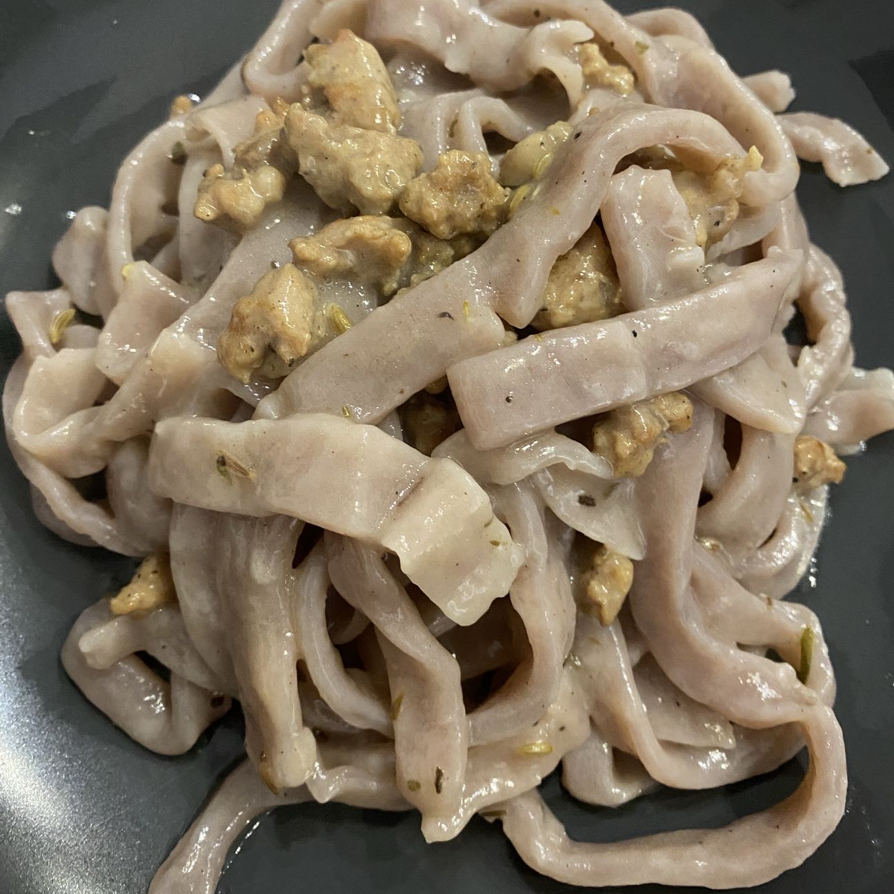 Fettuccine fatte a mano al vino rosso con salsiccia ed erbe aromatiche