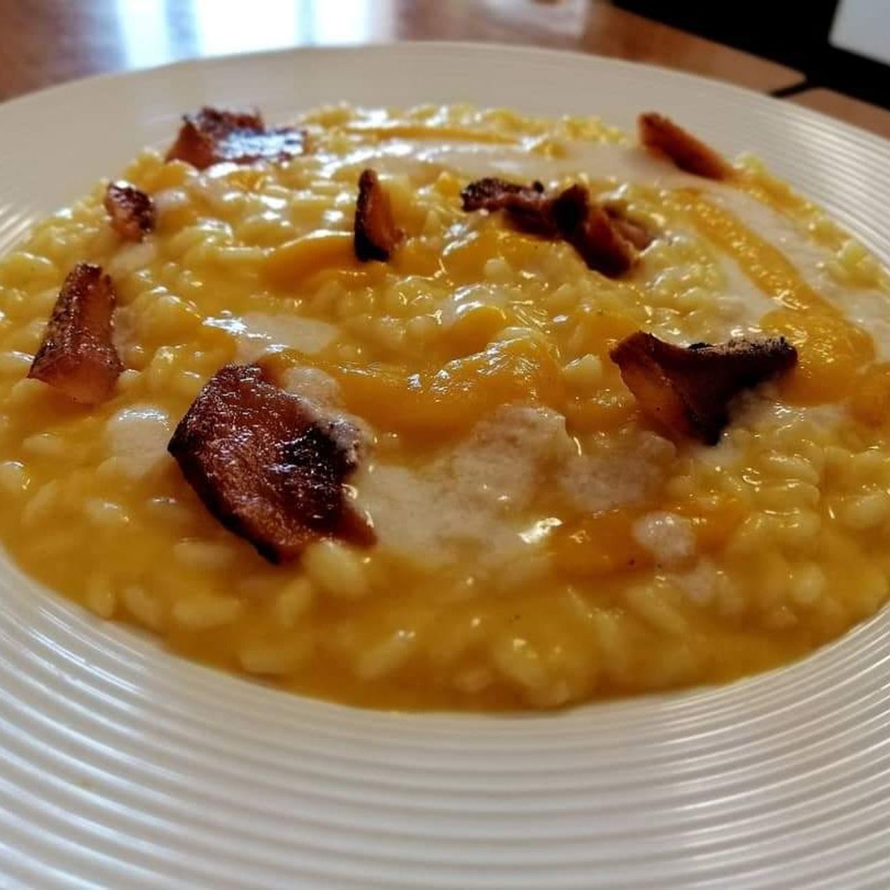Risotto con crema di zucca, provola affumicata e guanciale croccante