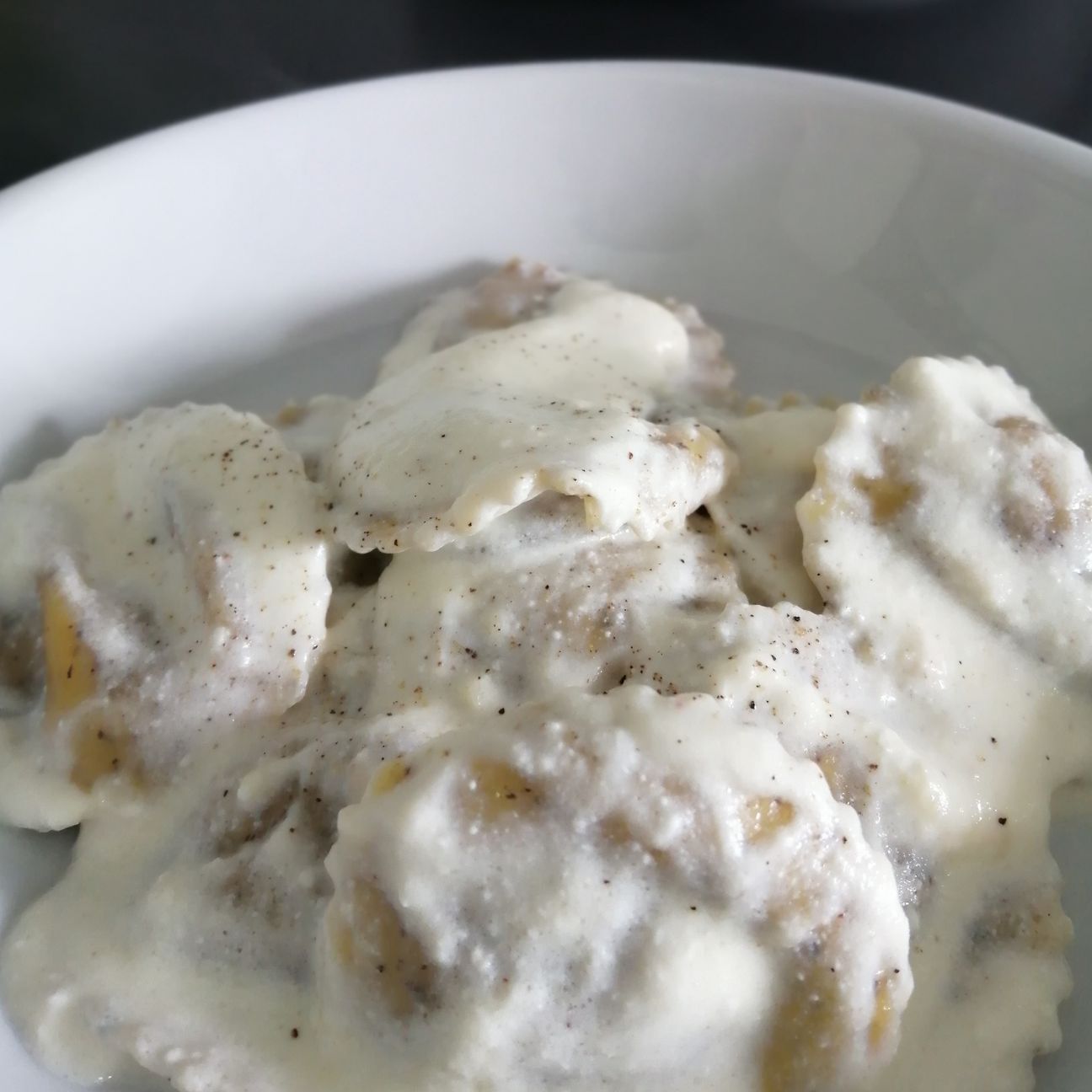 Ravioli di grano saraceno con ripieno di fontina e speck su crema di ricotta e Valle Latteria