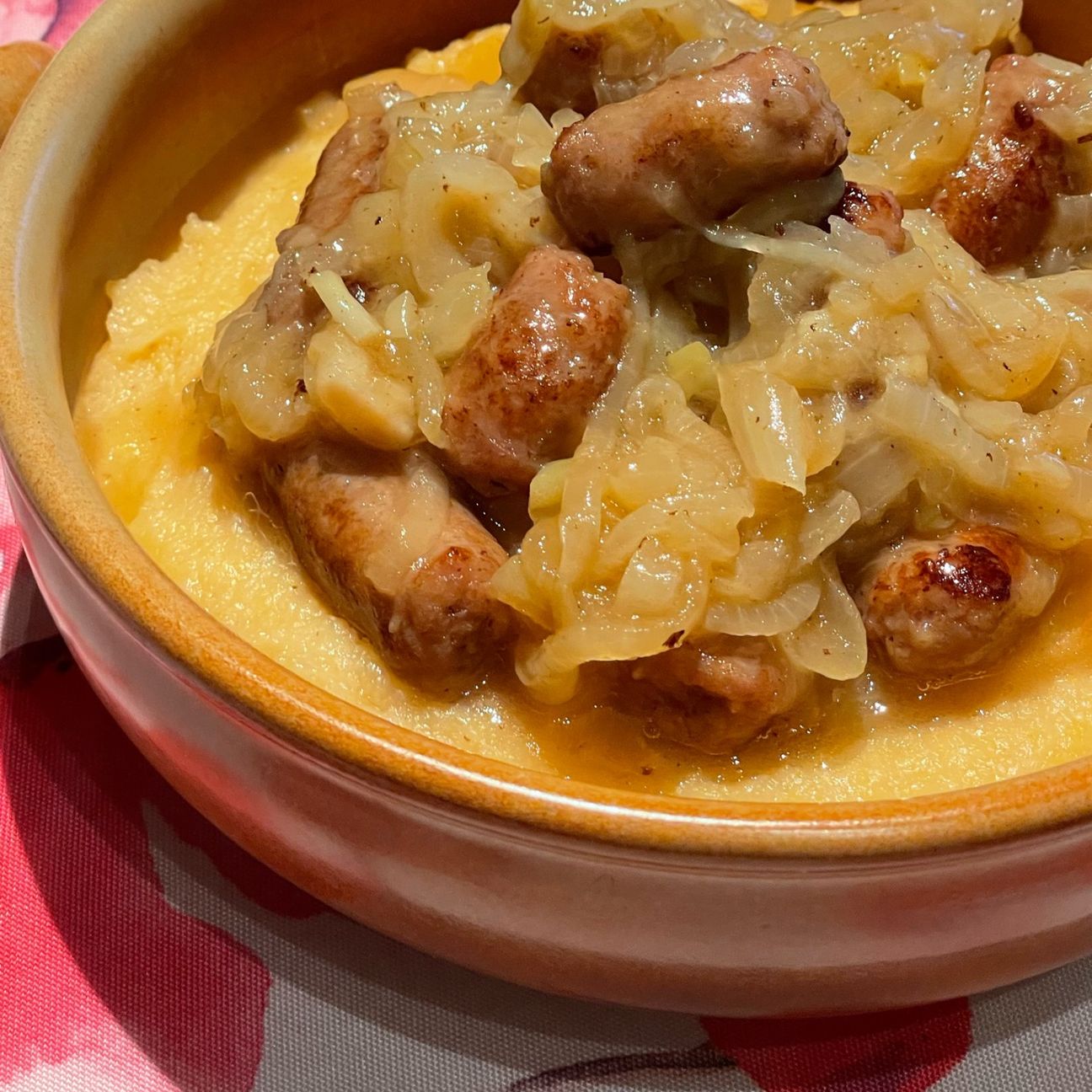 Polenta con cipolle e salsiccia in umido