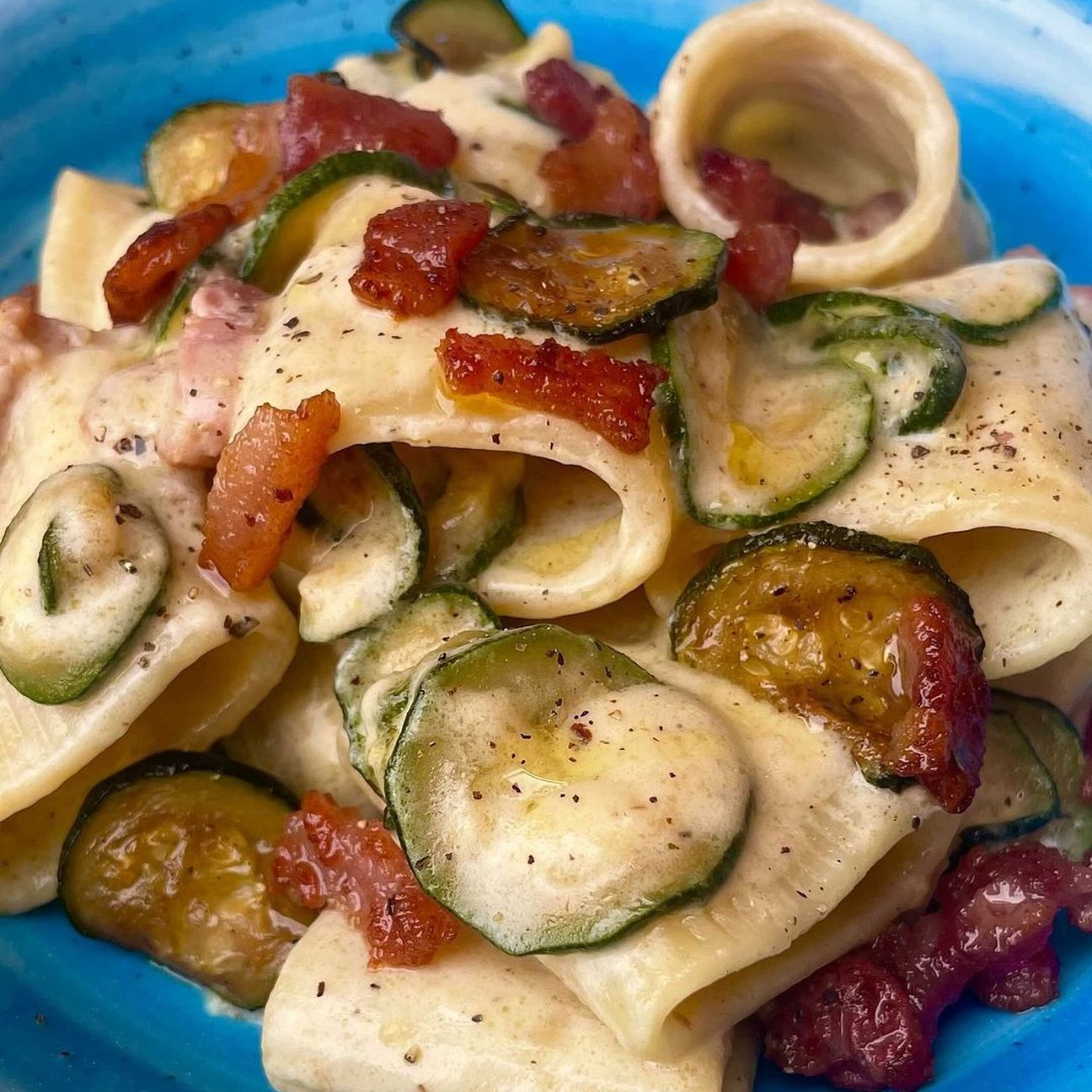 Mezzi paccheri cremosi con robiola, pecorino, zucchine e guanciale croccante