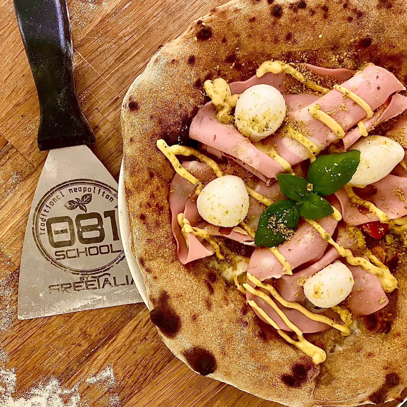 Pizza al caffè e mortadella con polvere di pistacchio
