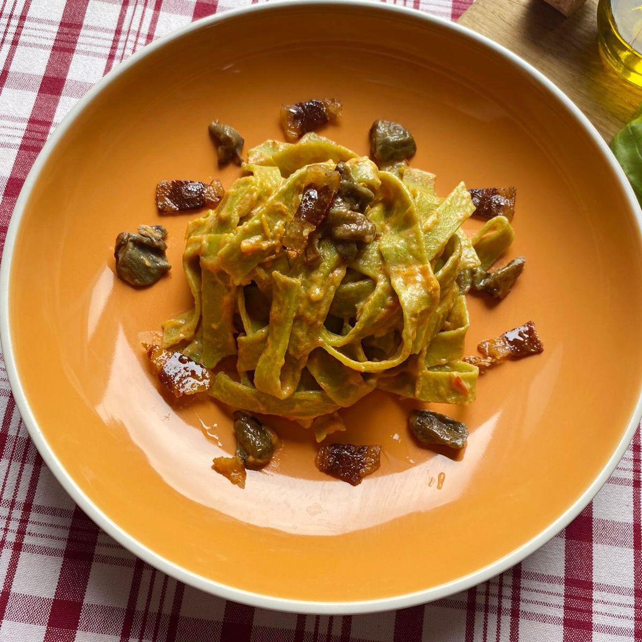 Tagliatelle di piselli con crema di peperoni, porcini e pancetta croccante