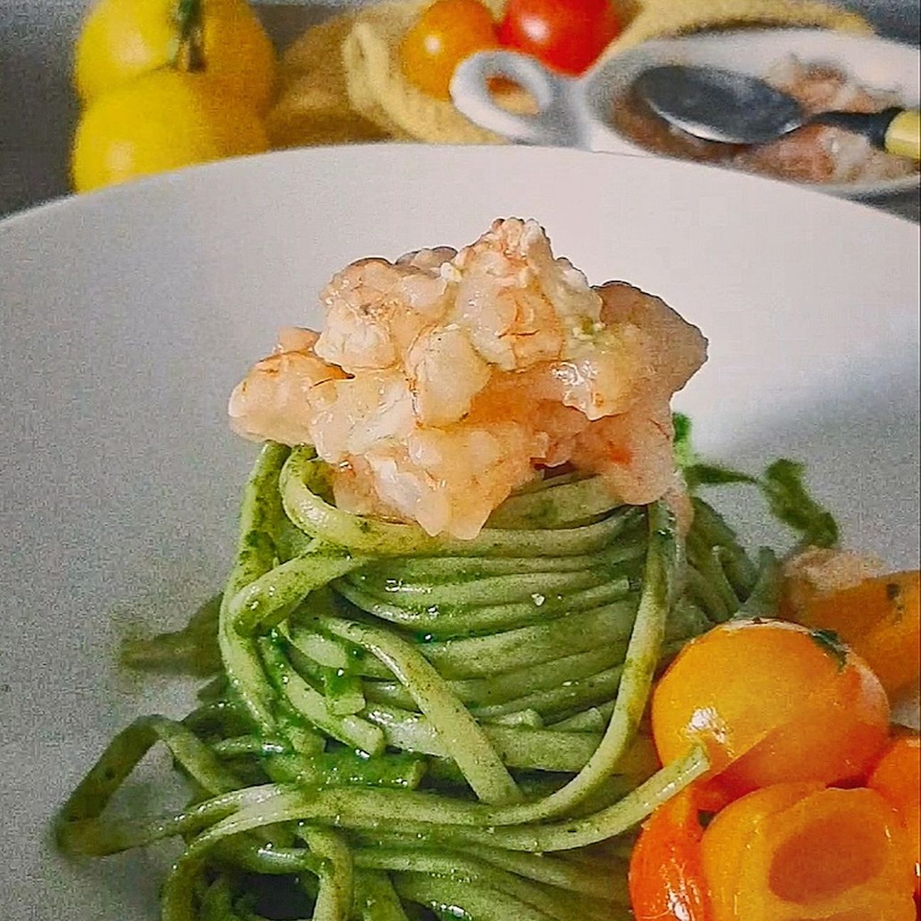 Linguine con crudo di gamberi rossi, bisque, pesto di cavolo nero e pomodorini