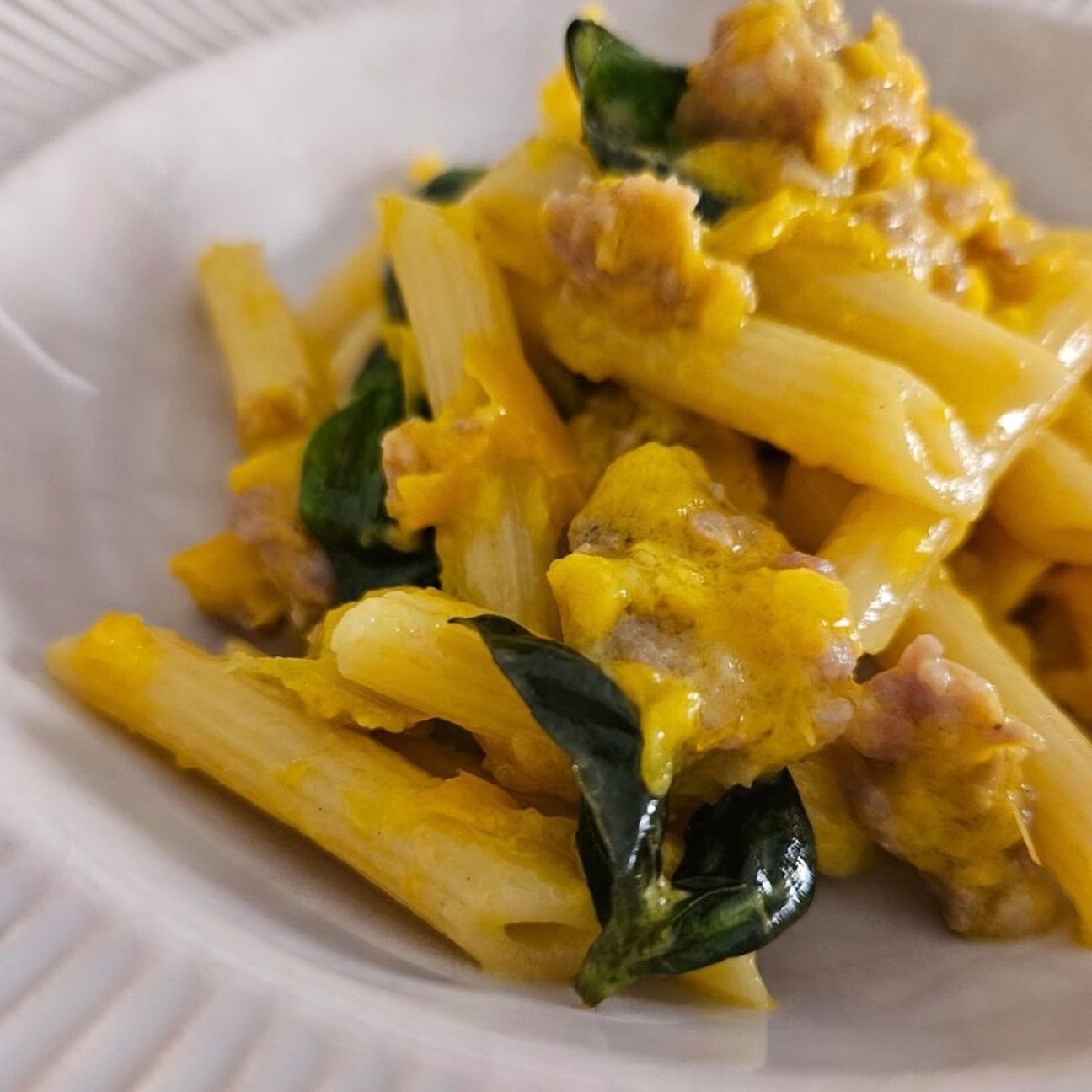 Pennette rigate con crema di peperoni gialli e salsiccia sbriciolata