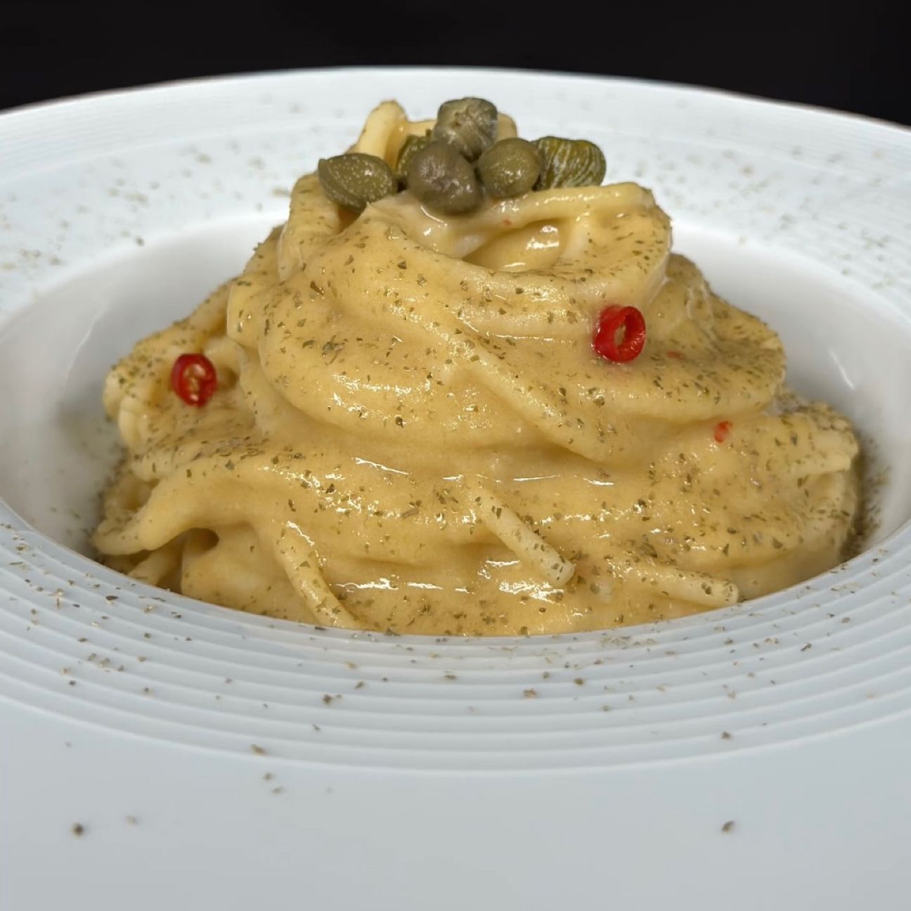Spaghetti con crema di ceci e polvere di capperi
