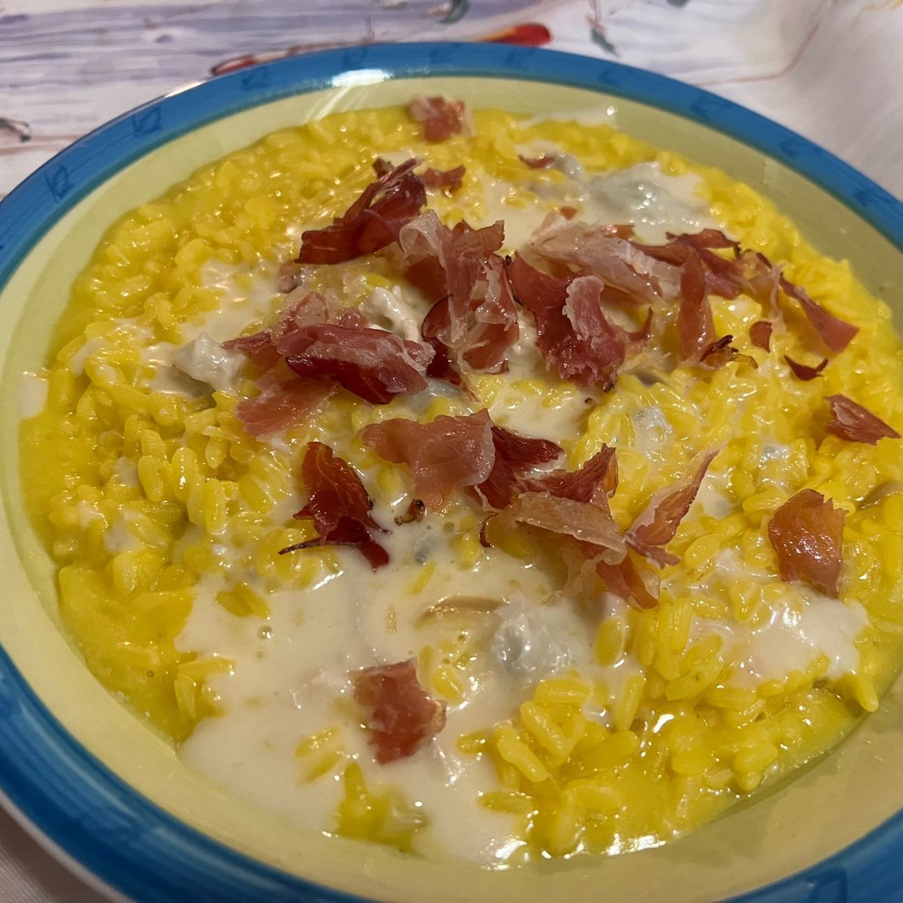 Risotto allo zafferano con fonduta al gorgonzola e petali di speck croccante