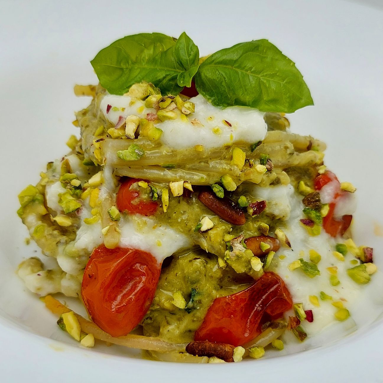 Spaghettoni pistacchiosi con pomodori datterini confit, Pinoli tostati e fonduta di parmigiano