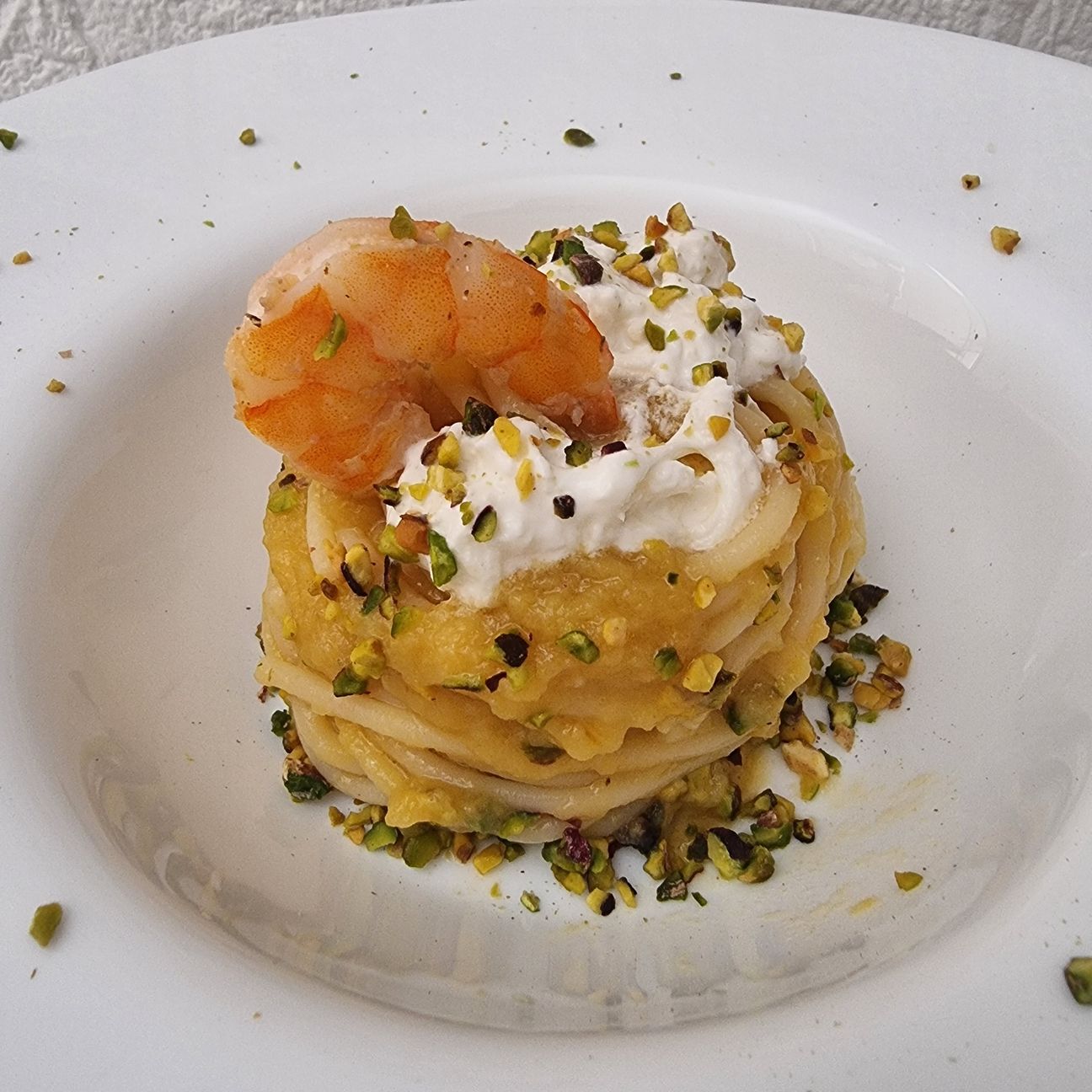 Spaghettoni con pomodoro giallo, gamberi, burrata e pistacchio