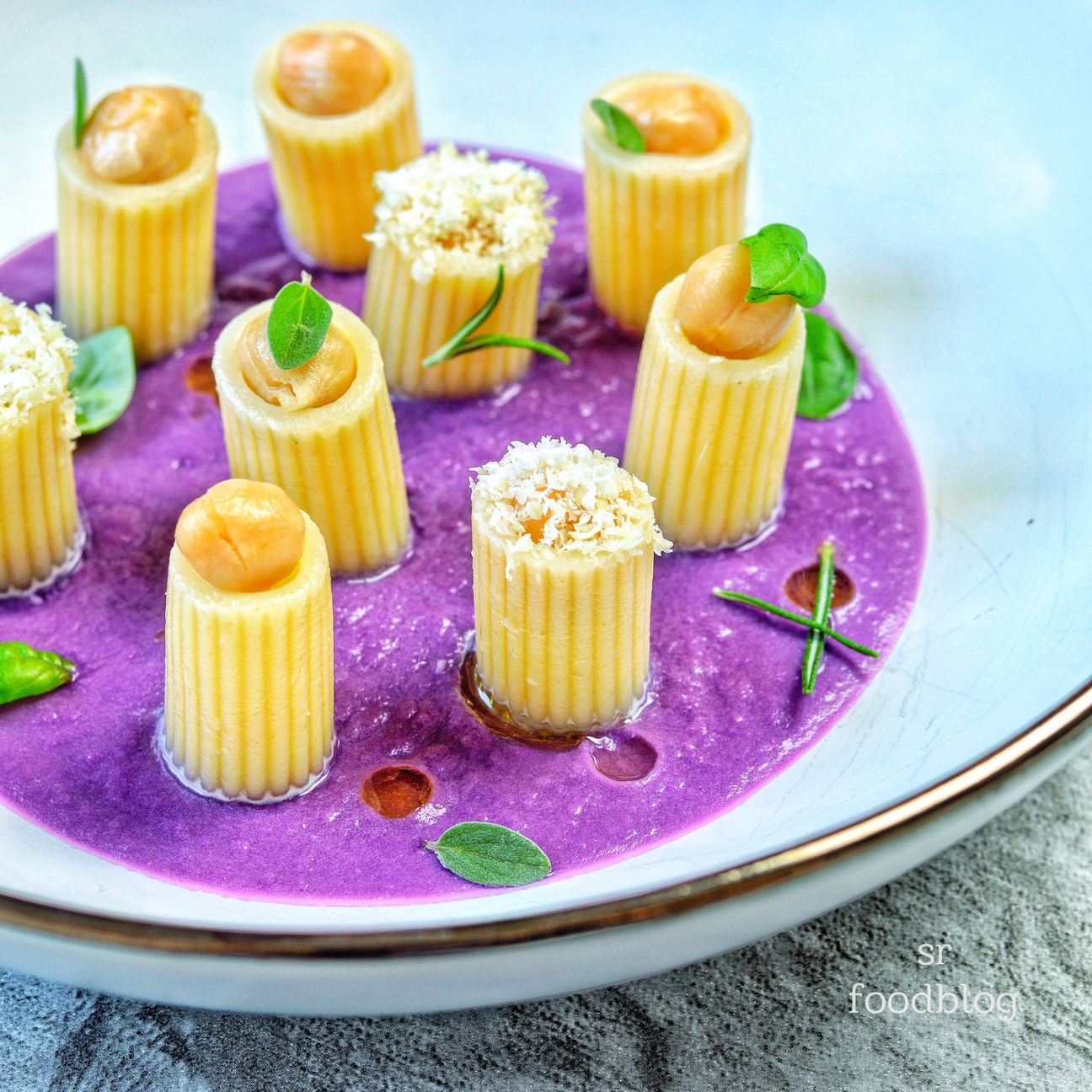 Mezzi paccheri rigati farciti di ceci su crema di cavolo viola e mandorle grattugiate