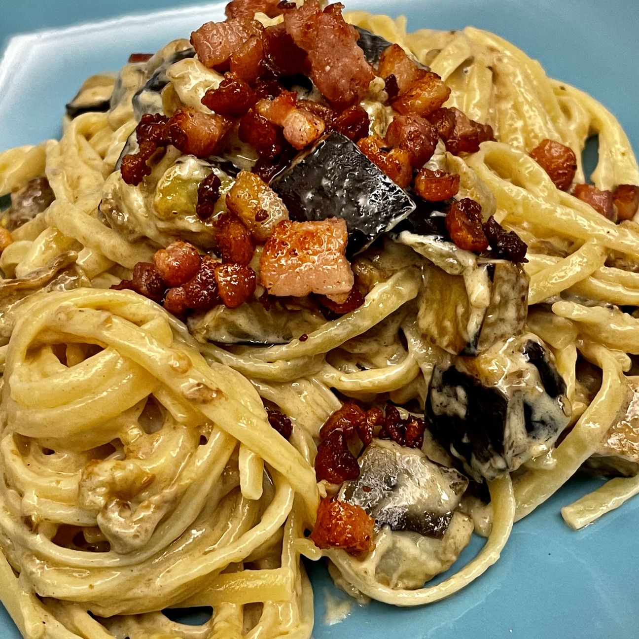 Linguine con crema di parmigiano, pancetta affumicata e melanzane fritte
