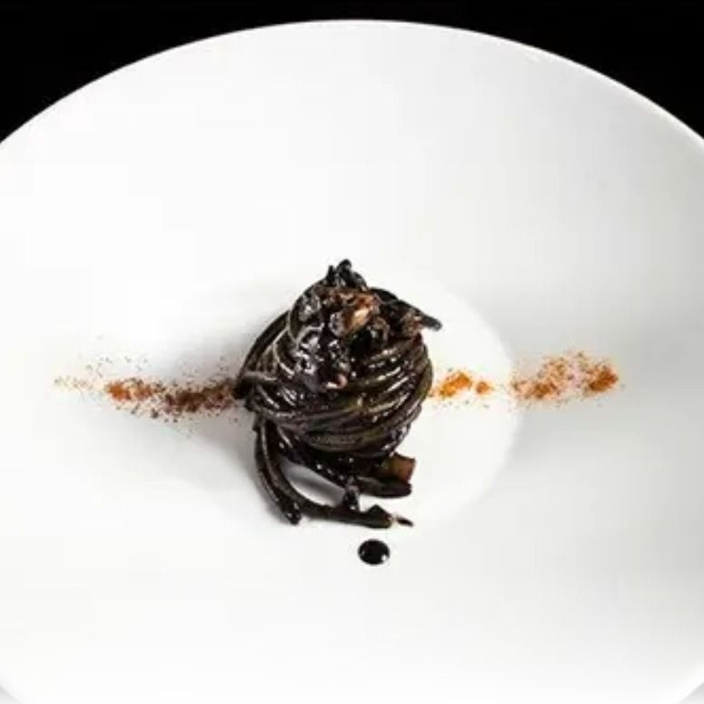 spaghetto al nero di seppia , acqua di mozzarella ,cocco e polvere di arancia