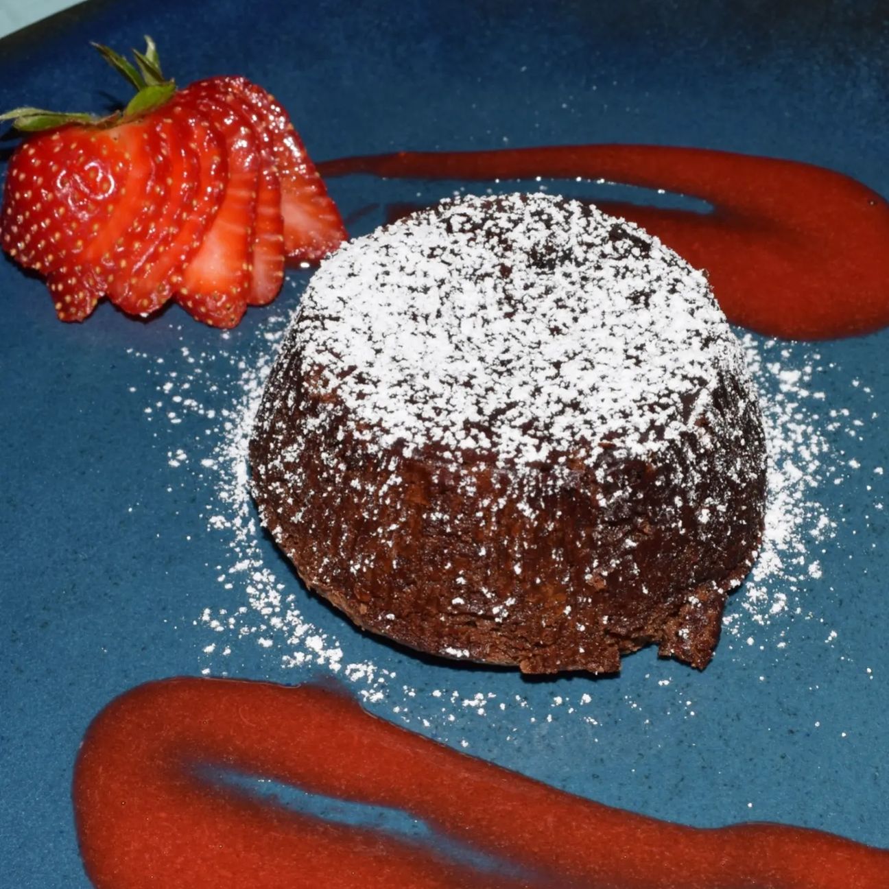 Tortino di cioccolato dal cuore morbido con coulis di fragole