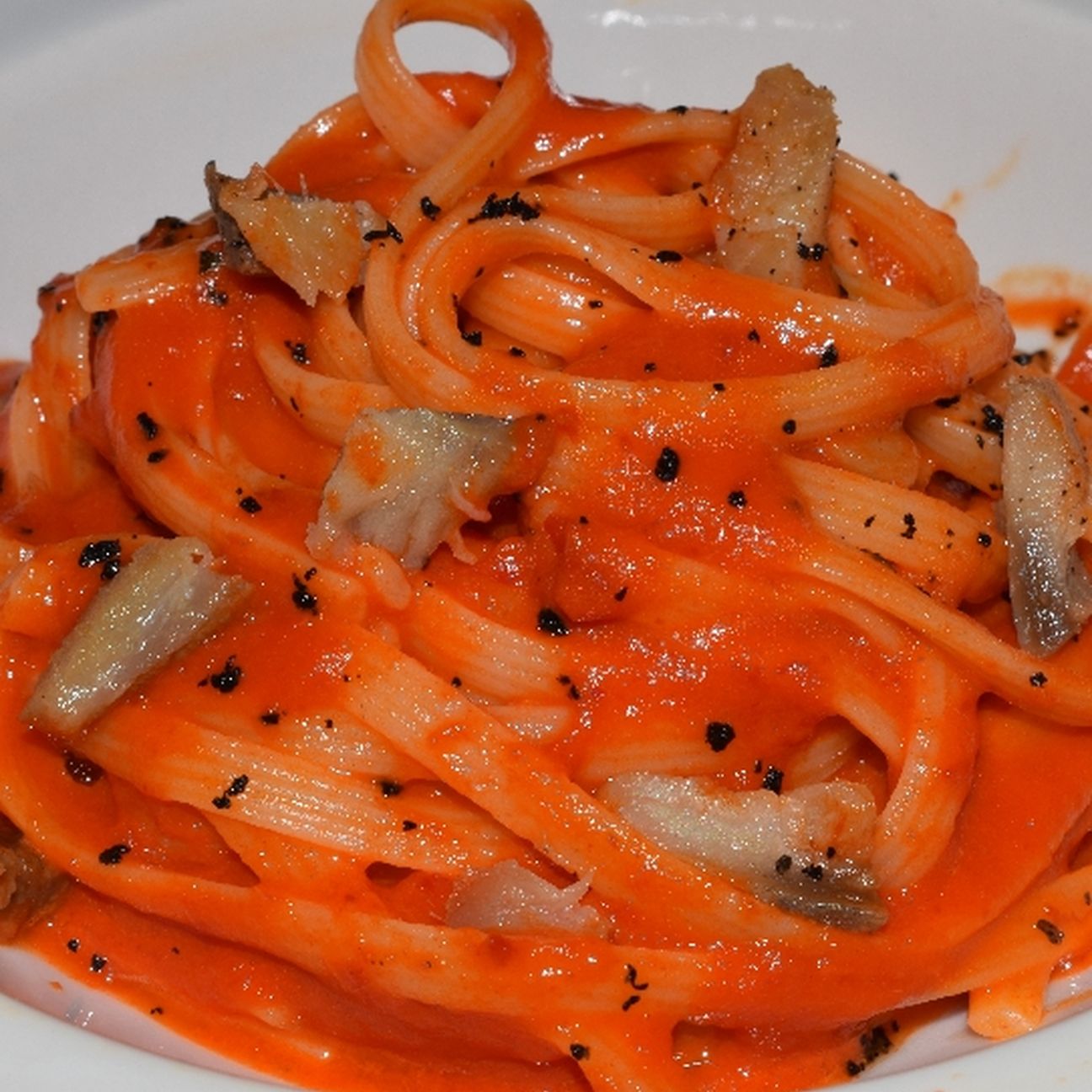 Linguine alla crema di peperoni, aringa affumicata e polvere di olive nere