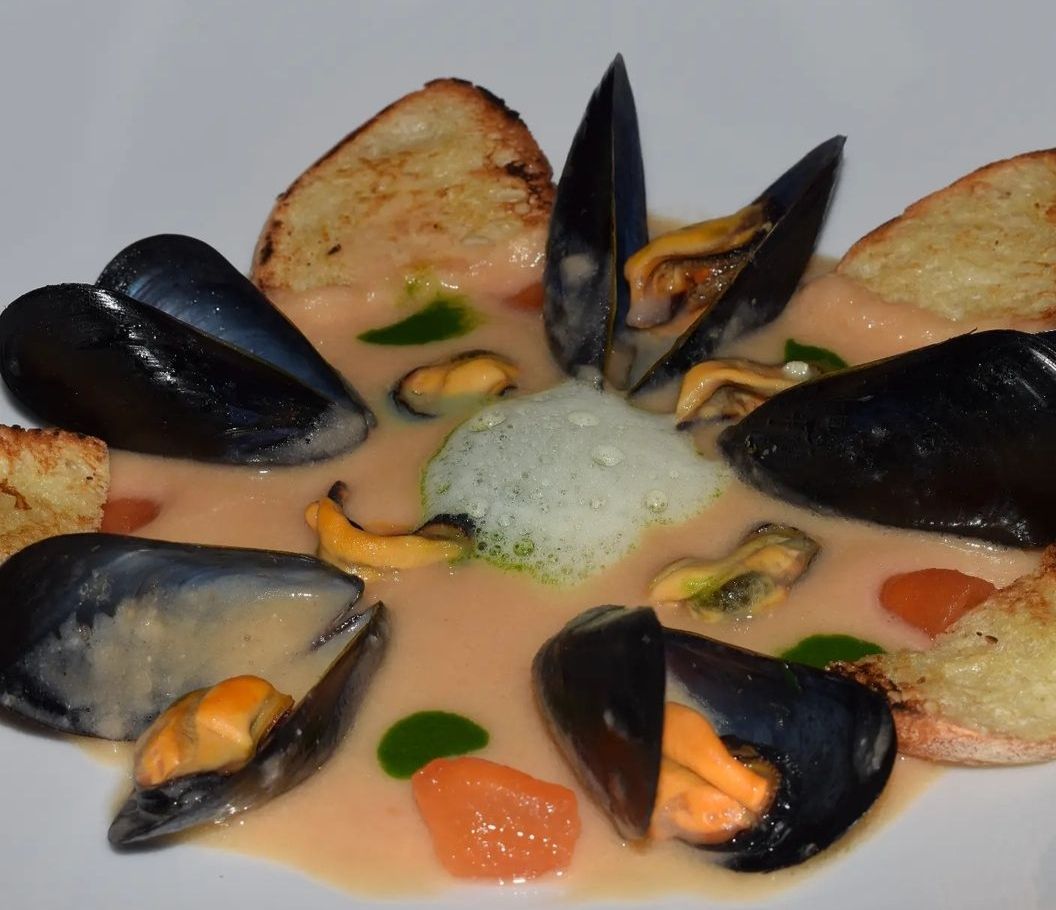 Cozze tarantine su crema di fagioli con crostini di pane e aria di prezzemolo
