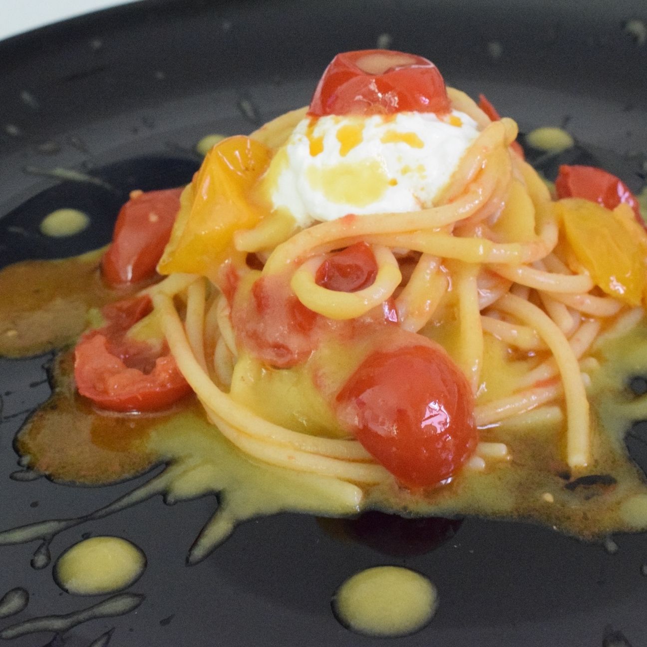 Spaghettoni con ciliegino, crema di datterino giallo e stracciatella.