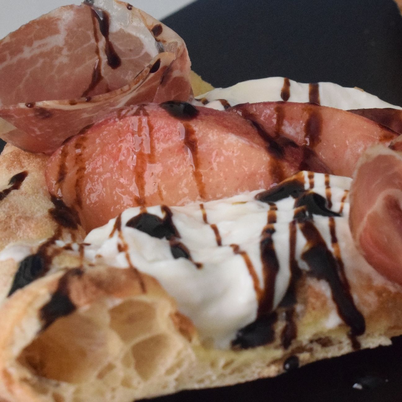 Pizza bianca con burrata, pesche e capocollo di Martina Franca.