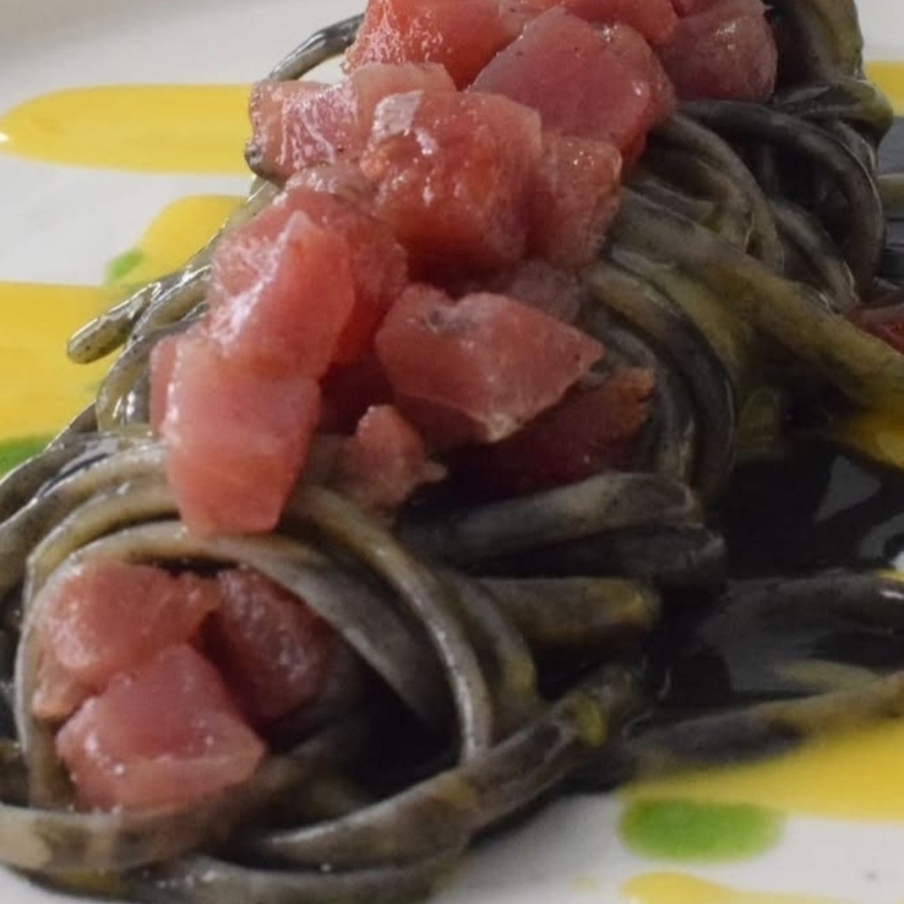 Fettuccelle al nero di seppia con tartare di tonno e salsa al mango