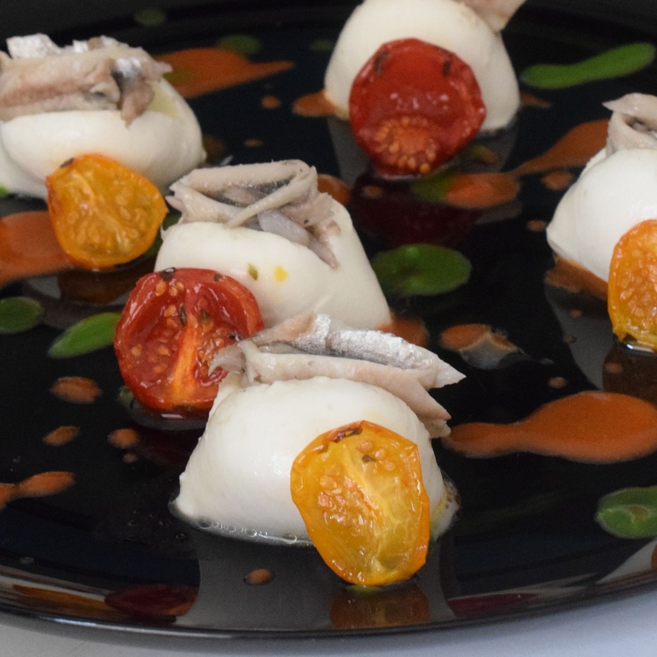Bocconcini di mozzarella con alici marinate e pomodori confit