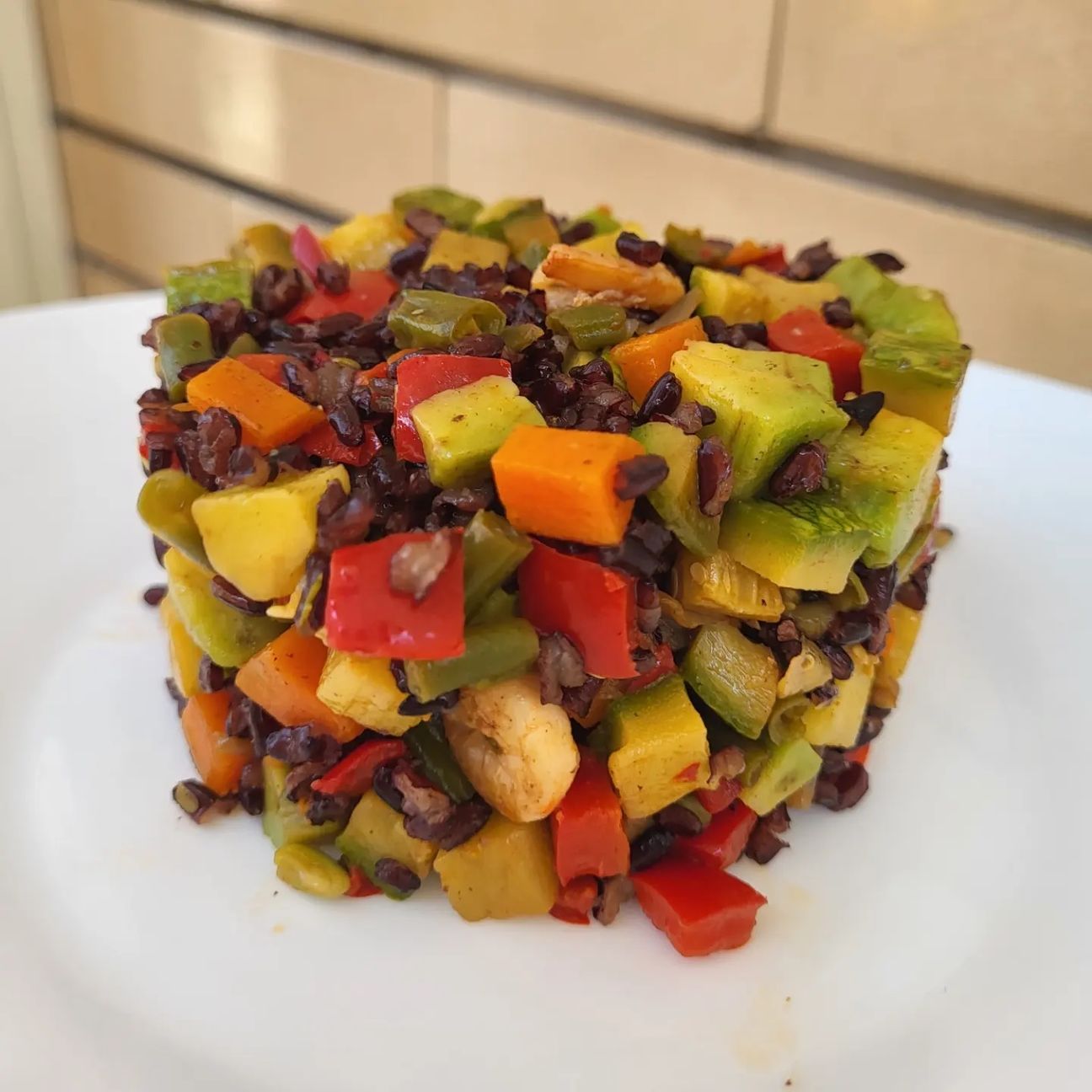 Riso venere con verdure saltate in padella, gamberetti e avocado