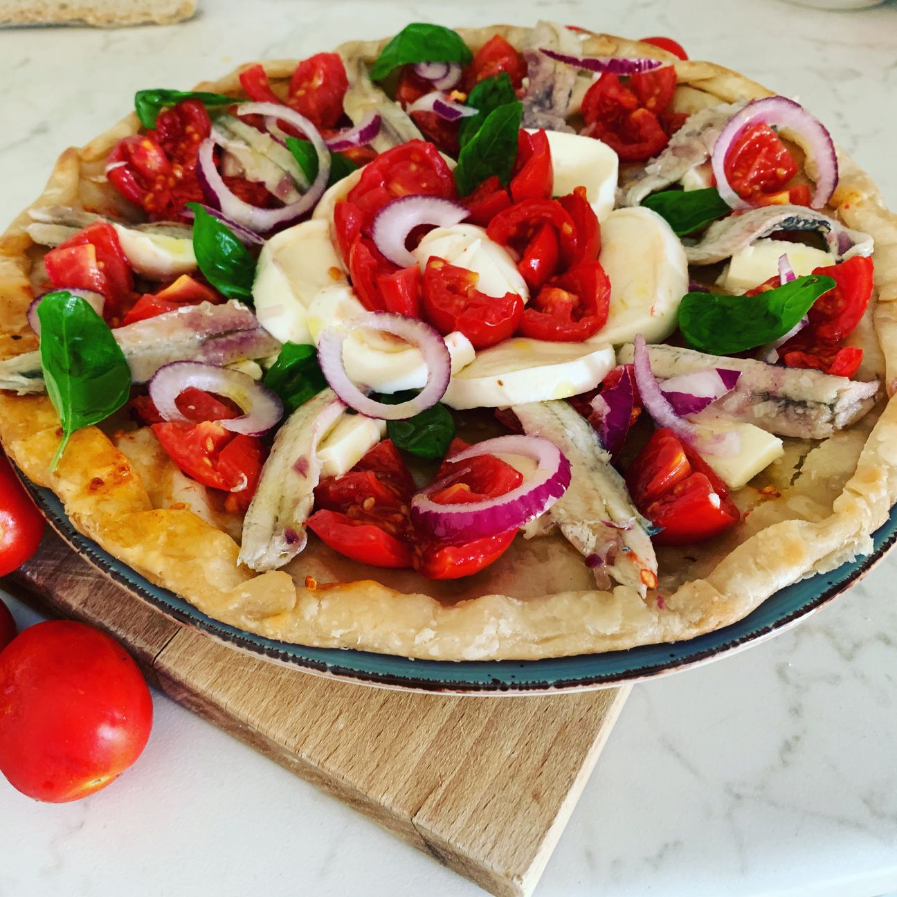 Pizza con pomodorini mozzarella cipolla di Tropea e basilico