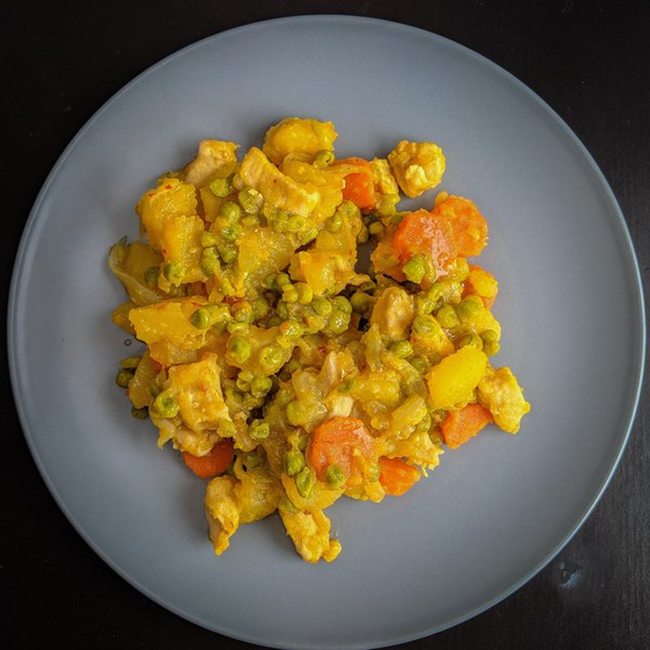 Spezzatino di pollo, carote, patate e piselli