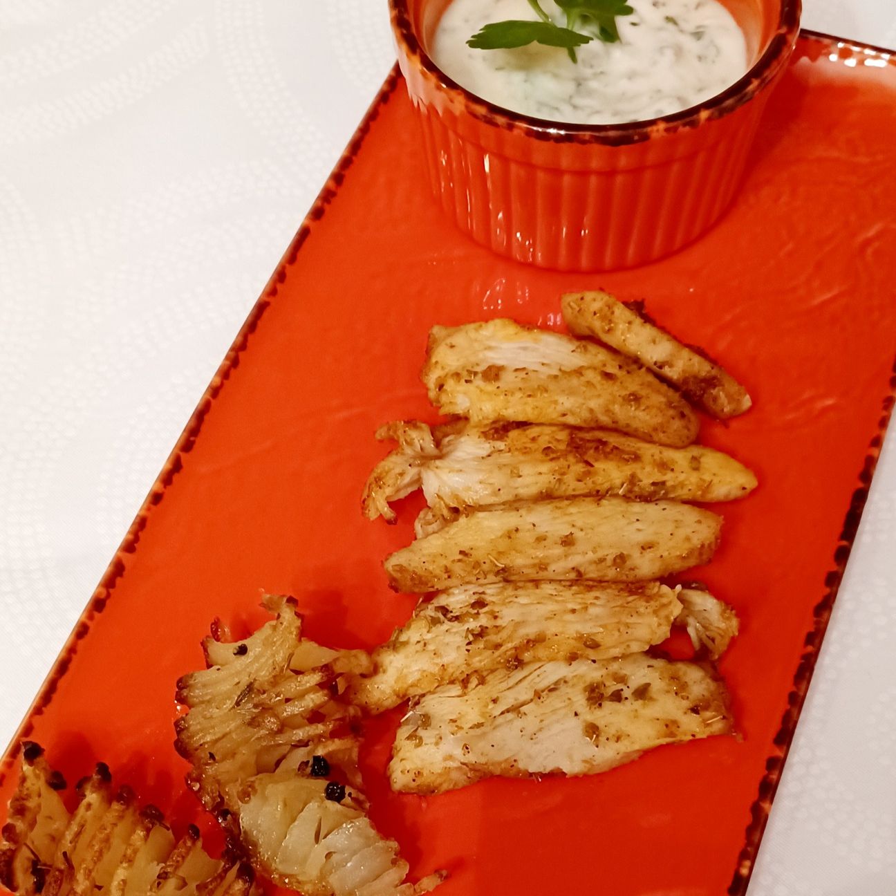Tagliata di pollo speziata, patate aromatizzate e salsa allo yogurt.