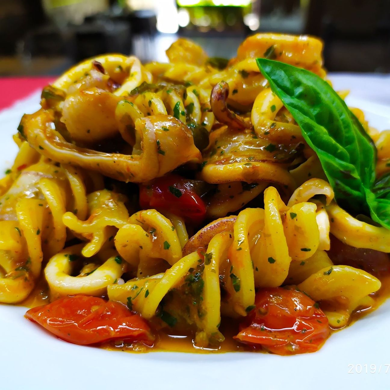 Fusilloni in salsa di pomodorini freschi, calamari, capperi e olive.
