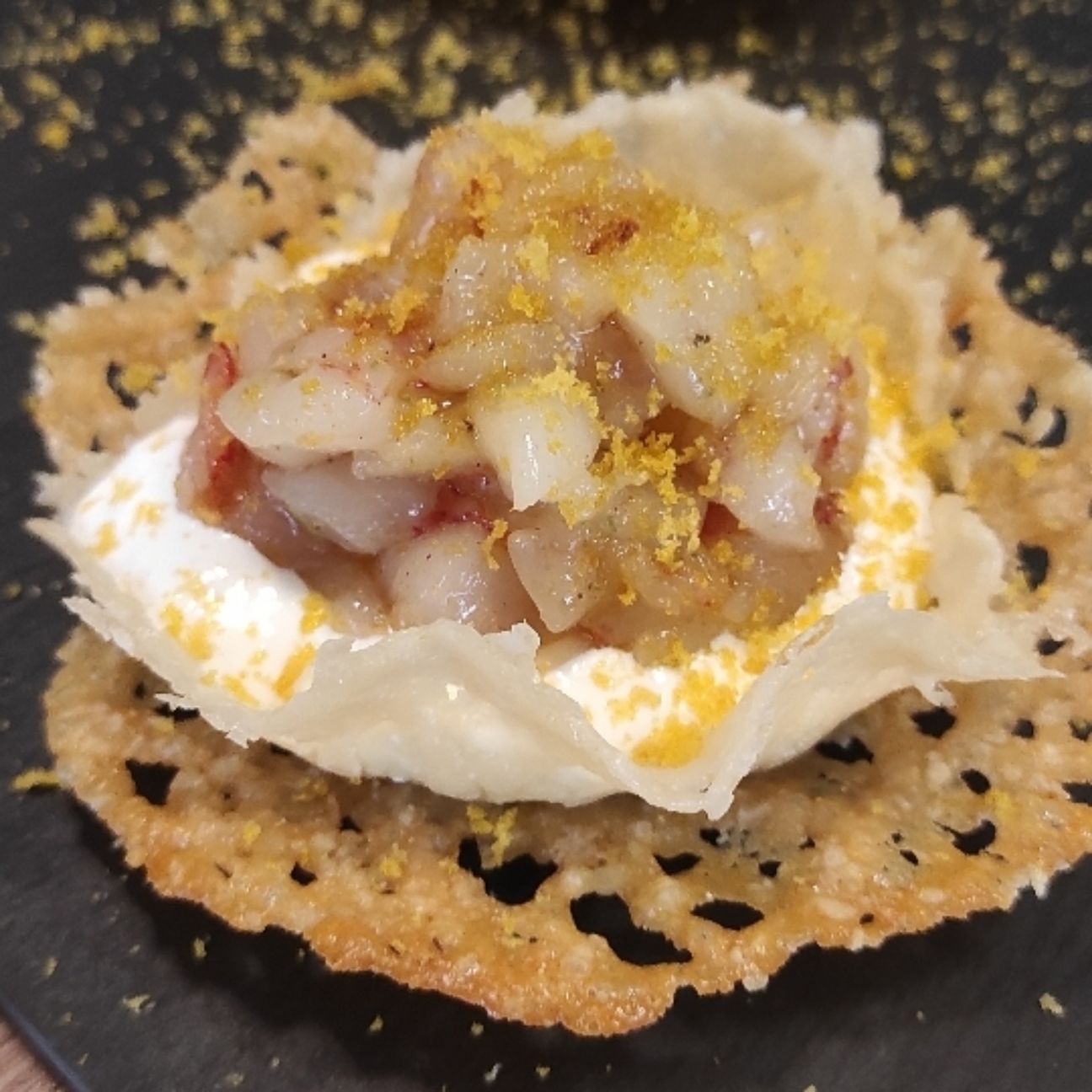 Nido di formaggio con burrata, tartare di gamberoni e bottarga