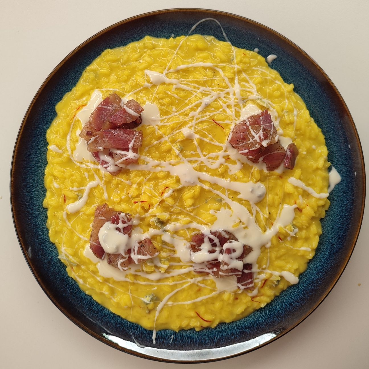 Risotto allo zafferano con pancetta croccante e panna acida al gorgonzola