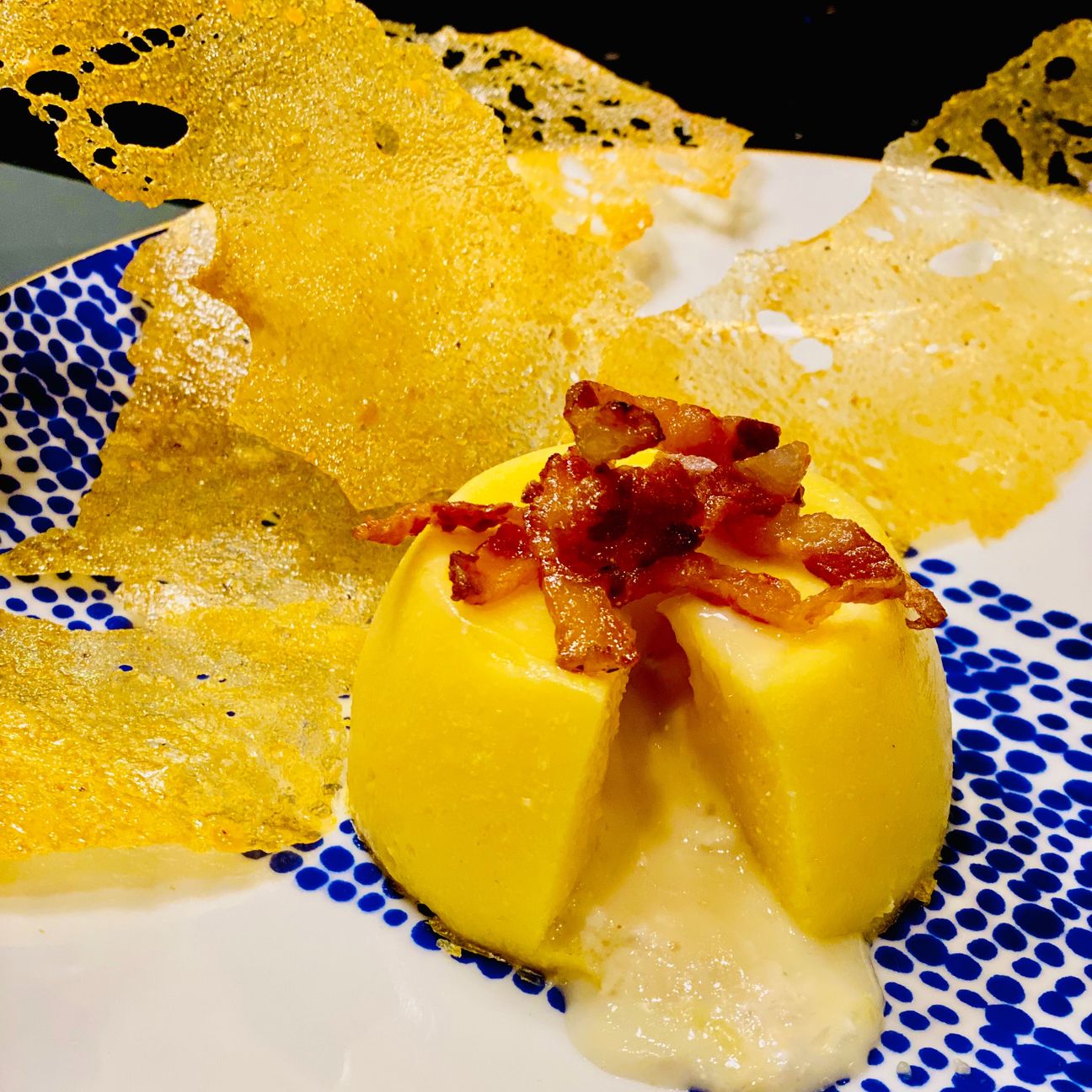 Tortino di polenta con cuore fondente , croccante di guanciale e chips di polenta