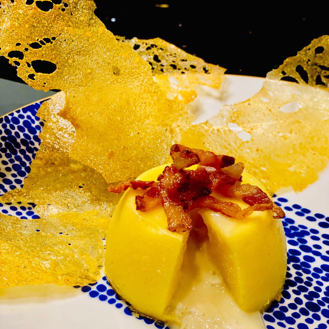 Tortino di polenta con cuore fondente, croccante di guanciale e chips di polenta