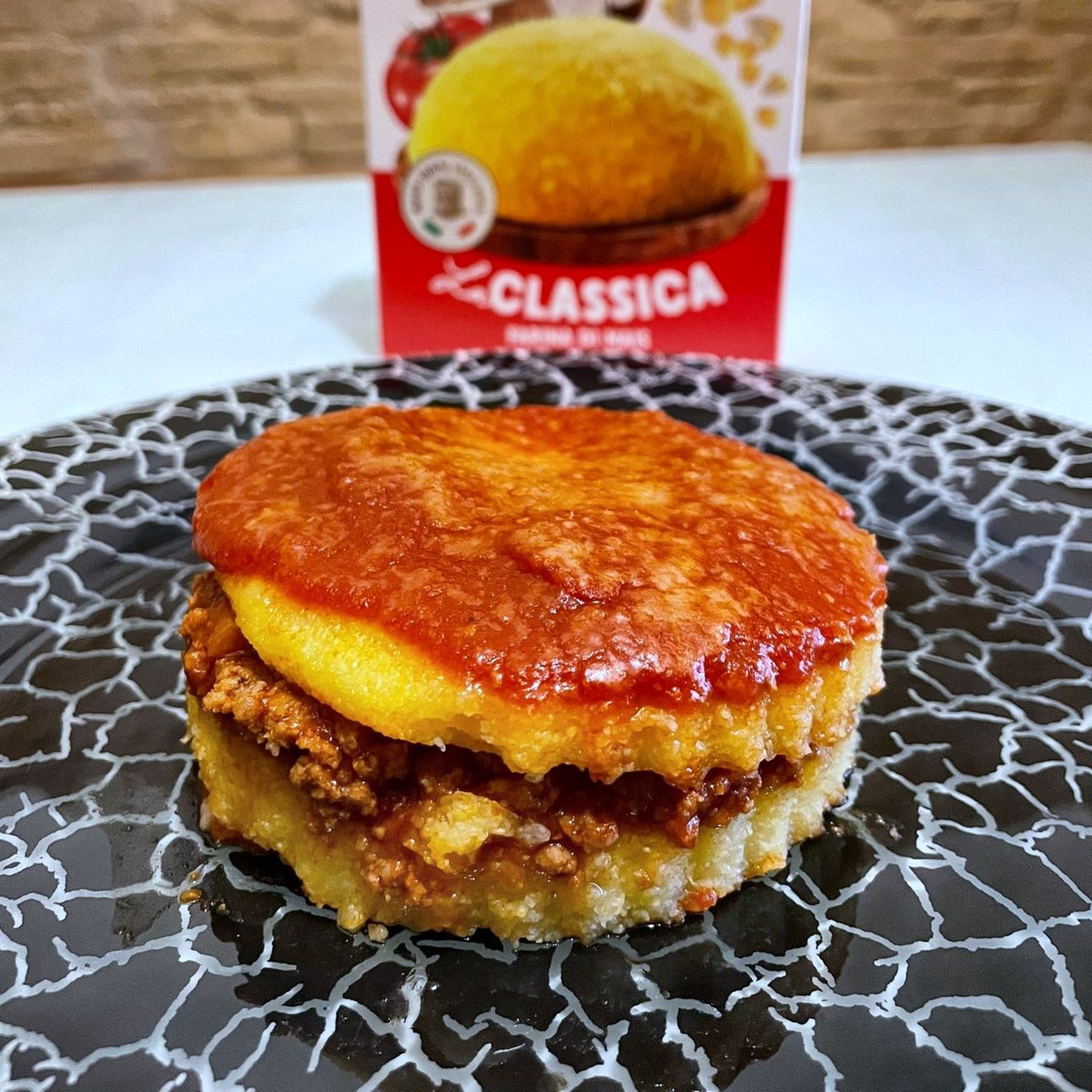 Torretta di polenta con ragù alla bolognese e formaggio filante