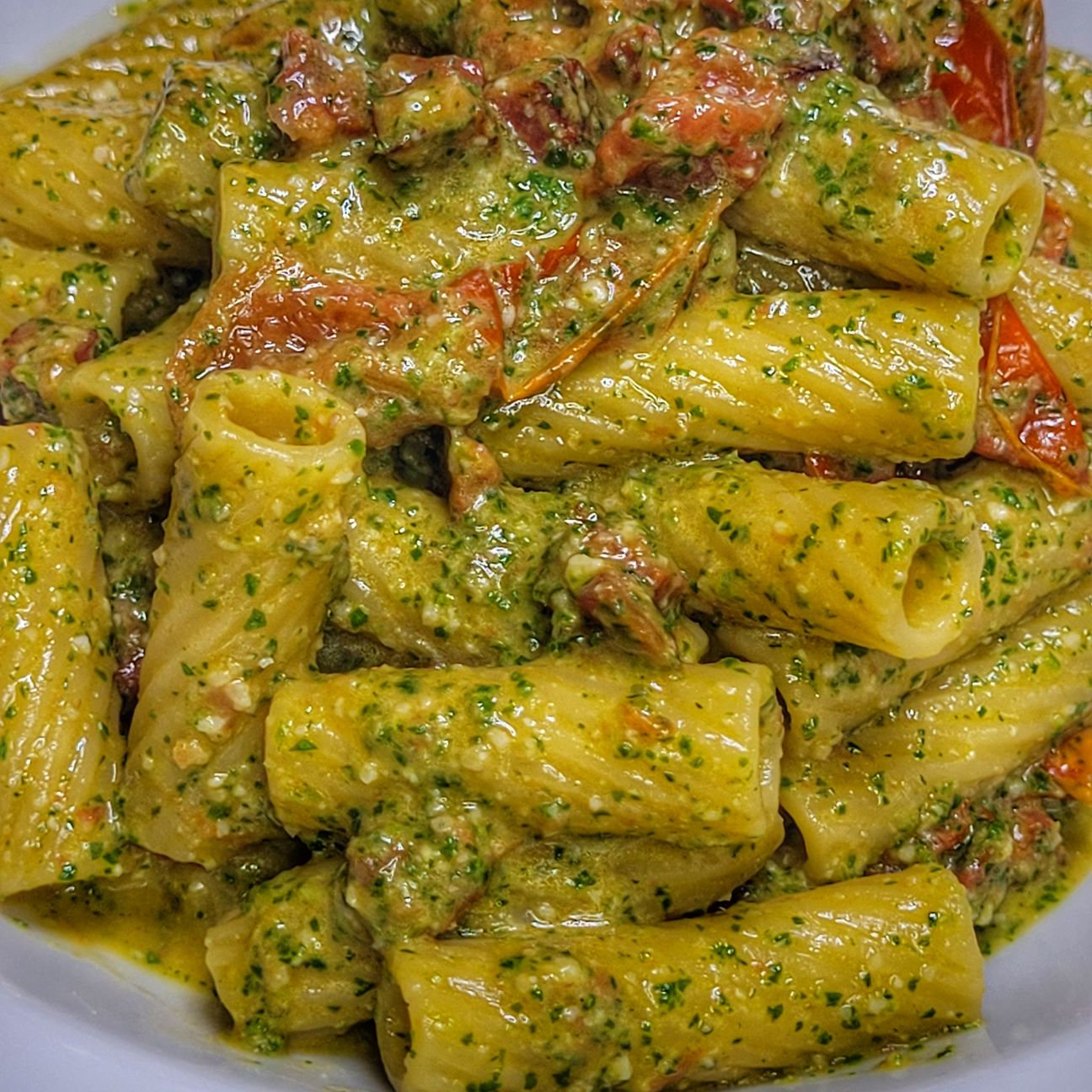 Tortiglioni con pesto di rucola e noci, spianata piccante e pomodorini