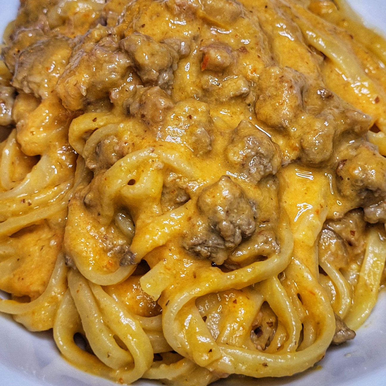 Fettuccine con crema di peperoni, tritato di manzo, salsiccia e cipolla