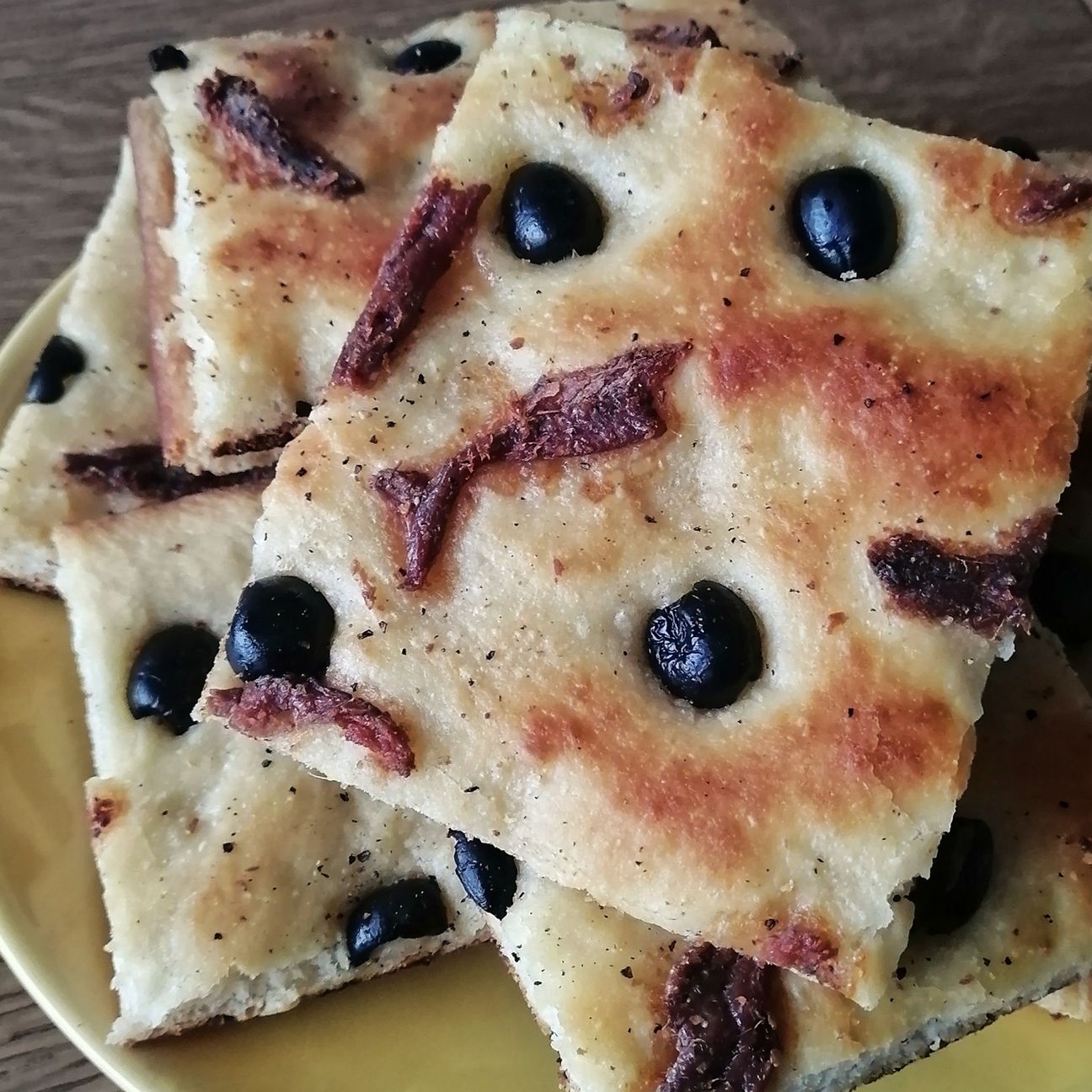 Focaccia ai fiocchi di patate con acciughe al tartufo e olive
