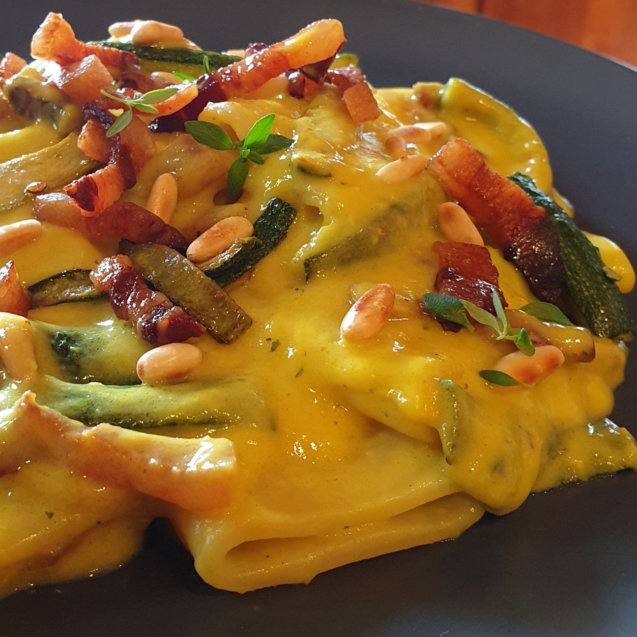 Paccheri in crema di zucchine con curcuma e zenzero, zucchine trifolate, guanciale e pinoli tostati