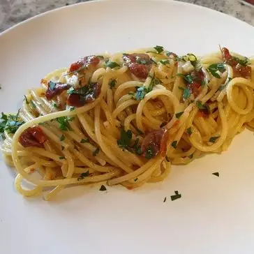 Ricetta Spaghetti aglio, olio e peperoncino con pomodori secchi e acciughe