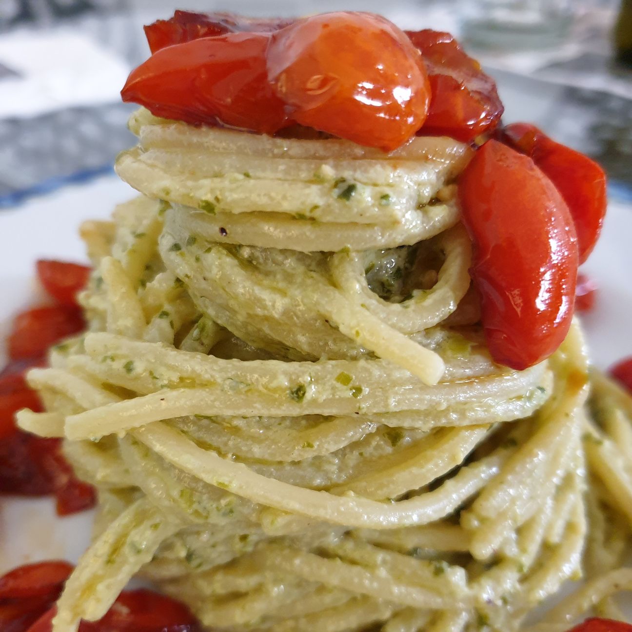 Spaghetti in crema di ricotta, basilico e pinoli con pomodorini datterini caramellati