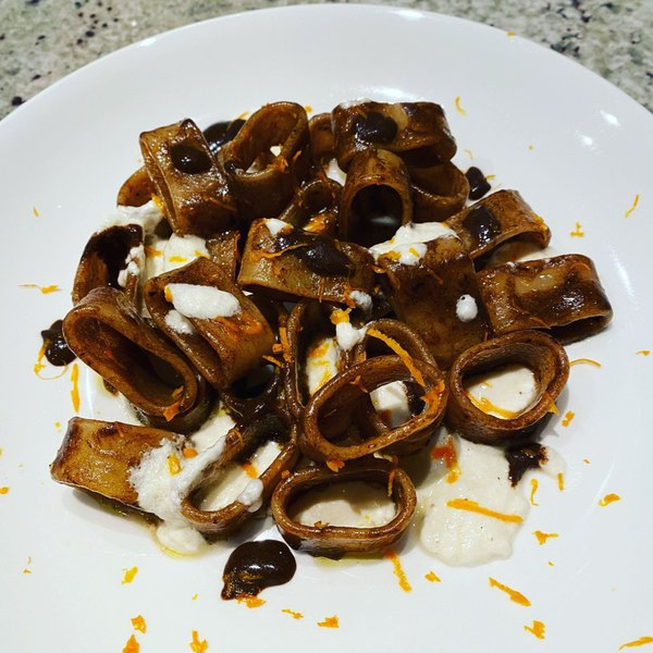 Calamarata in crema di aglio nero con burrata affumicata e scorzetta d'arancia
