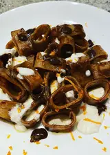 Ricetta Calamarata in crema di aglio nero con burrata affumicata e scorzetta d'arancia