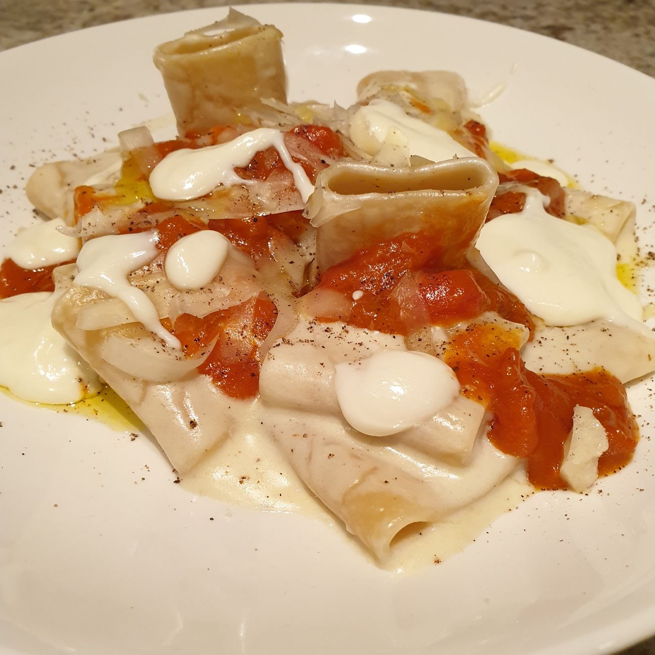 Paccheri con fonduta di pecorino, infusione di pepe e ragù ai ricci di mare