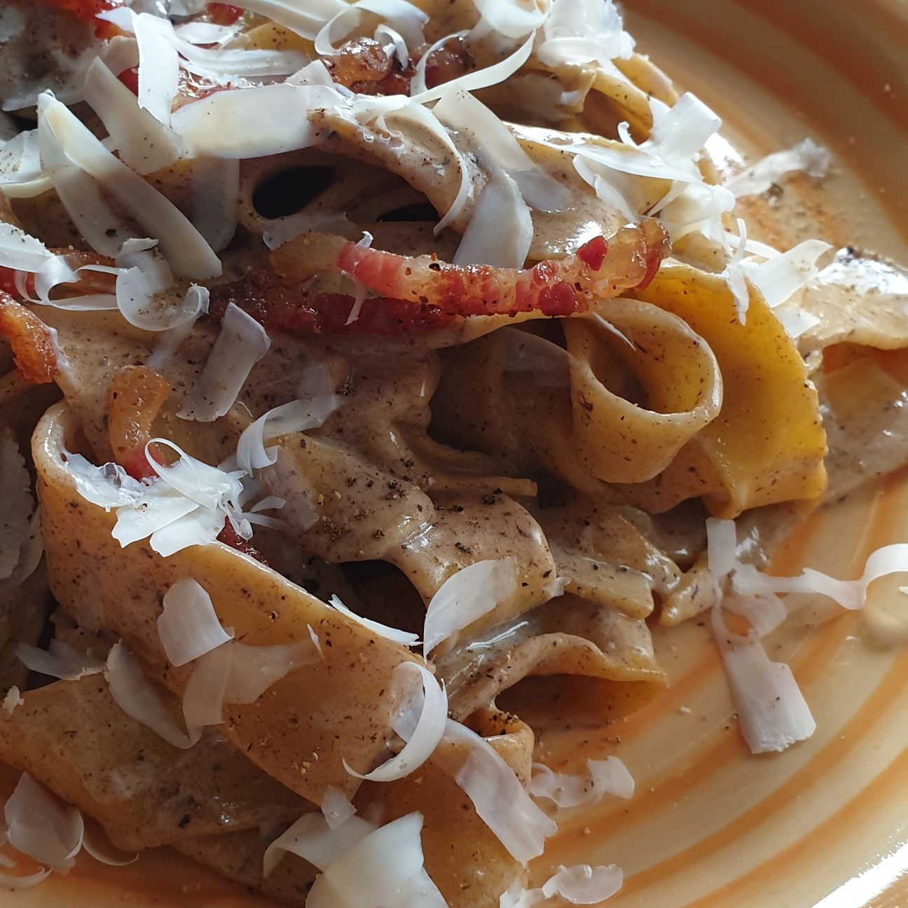 Pappardelle con crema di aglio nero e stracciatella, guanciale croccante e ricotta salata