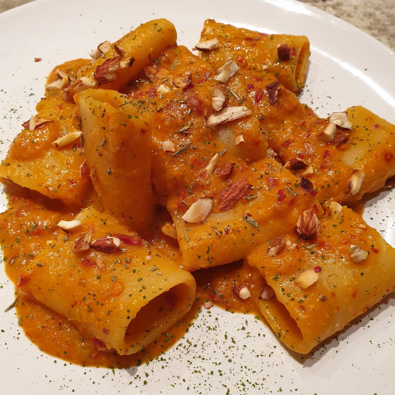 Paccheri con crema di ceci, 'nduja, granella di mondorle tostate e polvere di rosmarino